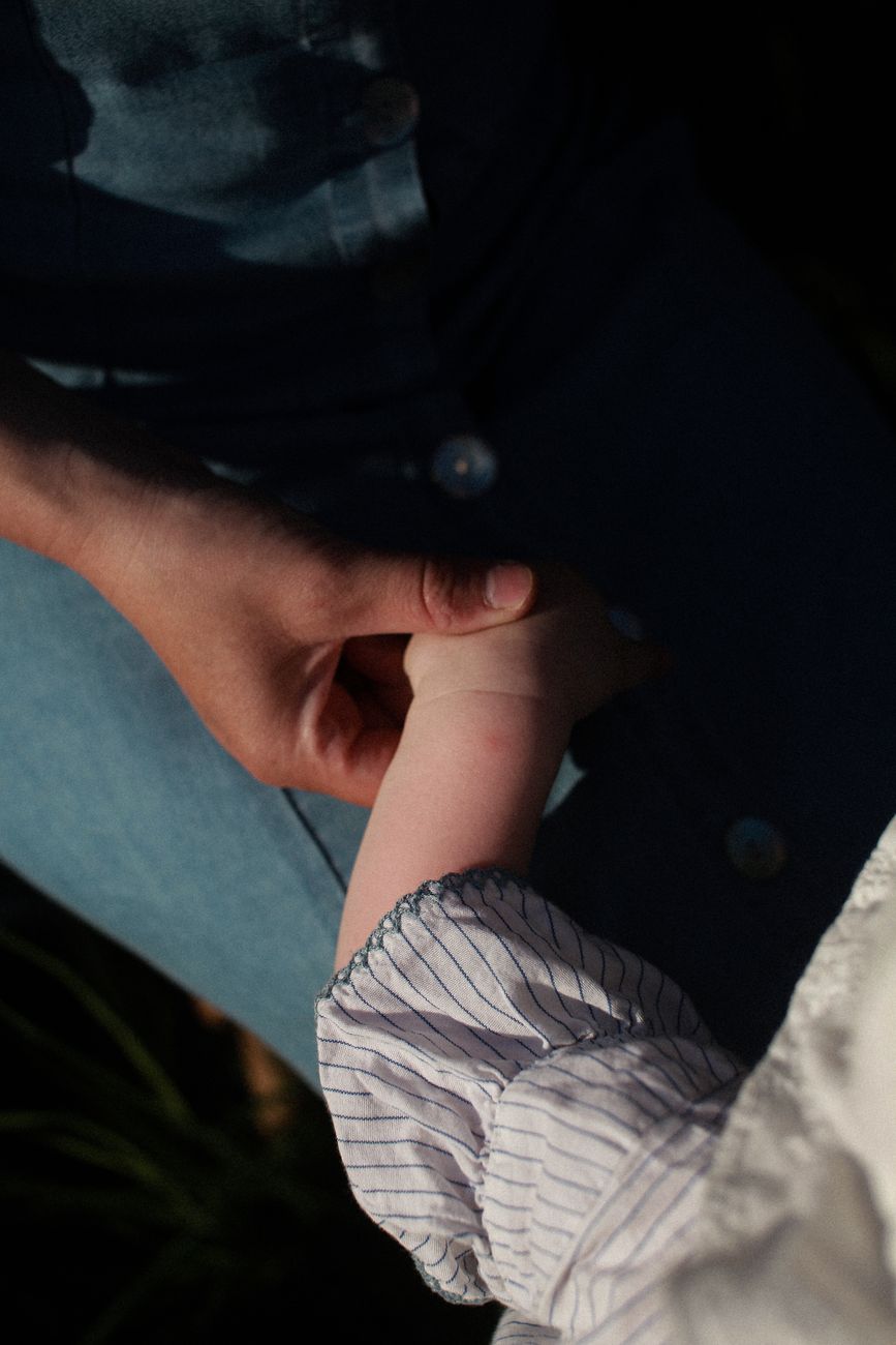 Mano de un adulto sosteniendo la mano de un niño